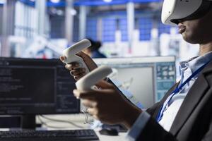 Woman in solar panel facility reviews photovoltaic system performance using VR goggles. African american employee analyzing production metrics using virtual reality tech to optimize efficiency photo