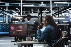 Engineer in AI server hub panicked by hacker attack stealing sensitive information, trying to protect hardware. Artificial intelligence data center worker scared by virus during security breach photo