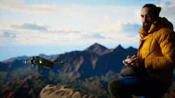 Traveler balances adventure and creating content by filming with his drone, recording the aerial view of a beautiful mountain range. Breathtaking landscape scenery videography. Camera A. photo