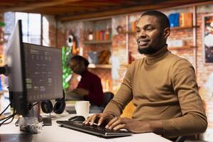 Upbeat IT engineer coding advanced AI algorithm in startup office, refining machine learning models to enhance automation. Cheerful man using coding platform in Silicon Valley workplace photo