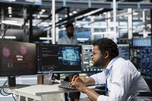 Engineer upset by critical error message while setting up data center equipment for artificial intelligence processes. Angry server room worker annoyed by AI software on PC not working properly photo