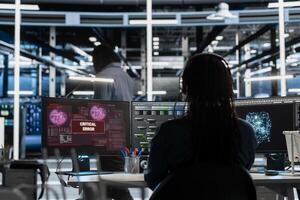 Server room expert receiving critical error popup on PC while using artificial intelligence to reduce downtime. Admin dealing with bugs, getting warning message while implementing AI in data center photo