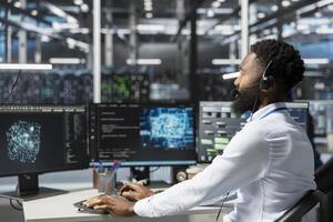 Employee talking in headset mic with technicians setting up data center equipment needed to run artificial intelligence. Server room worker in remote call with engineers installing AI tools photo