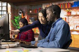 Asian call center senior manager providing guidance to multiethnic team, addressing questions. Customer support workplace onboarding specialist conducts orientation sessions for multiracial coworkers photo