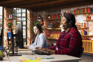 Call center agent laughing at funny joke while talking with customer in office. Customer service representative amused by comical conversation with client while providing assistance photo