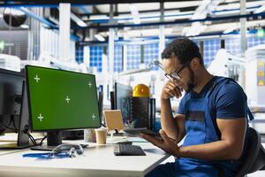 Manufacturing plant employee reviews data on green screen pc to improve the production line, eco friendly solar power. Solar panels factory technician identifying system errors using mockup. photo