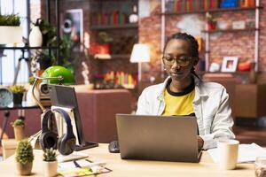 Remote worker in home office typing on laptop keyboard, preparing presentation slides, adjusting layouts. Freelancer finishing company project, writing summaries, saving files on notebook photo