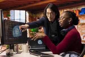 Man in AI startup office CTO position overseeing software technician implementing machine learning. Artificial intelligence tech venture experienced supervisor helps staff member to fix code bugs photo