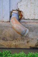 Round iron pipe for drainage above the gutter. Waste drainage from a factory built in the area outside the factory area. Hazardous waste management. Health, Safety and Environment. Text space photo