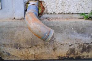 Round iron pipe for drainage above the gutter. Waste drainage from a factory built in the area outside the factory area. Hazardous waste management. Health, Safety and Environment. Negative space photo