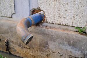 Round iron pipe for drainage above the gutter. Waste drainage from a factory built in the area outside the factory area. Hazardous waste management. Health, Safety and Environment. Copy space photo