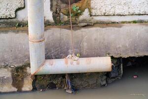 Iron pipe for drainage above the gutter. Waste drainage from a factory built in the area outside the factory area. Hazardous waste management. Health, Safety and Environment photo