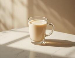 Glass Mug with Beige Liquid on Table in Sunlight photo
