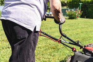 Mowing the lawn with a machine in a garden, outdoors photo