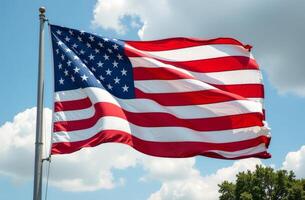 American flag waving against a backdrop of blue skies and clouds during the day photo