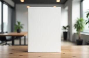Minimalist blank book on a wooden table in a modern workspace with plants and natural light during the day photo