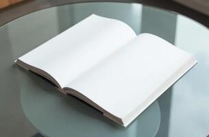 An open blank book resting on a glass table, inviting creativity and ideas during a quiet afternoon photo