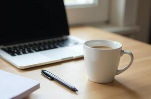 A steaming cup of coffee sits beside a laptop on a wooden desk, creating a cozy workspace atmosphere in natural light photo