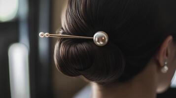Elegant pearl hairpin securing a sleek updo, showcasing classic fashion details and refined accessories for special occasions photo