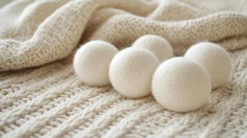 Soft white wool dryer balls on a knitted blanket in a cozy home setting for eco-friendly laundry care photo