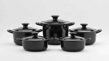 Five black ceramic cookware pieces arranged together showcasing their elegant design and functionality in a minimalist style photo