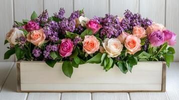 Stunning floral arrangement featuring roses and lilacs in a rustic box on a wooden surface photo