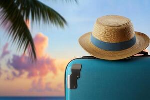 Vacation preparation with a suitcase and straw hat against a tropical sunset photo