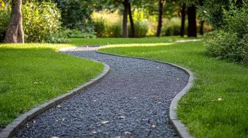 Curved gravel pathway winding through a lush green park during late afternoon photo