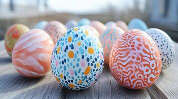 Colorful hand-painted Easter eggs arranged on a wooden surface during daylight, showcasing intricate designs and patterns photo
