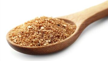 Brown sugar on a wooden spoon showing its rich texture and color for culinary use in desserts and baking photo