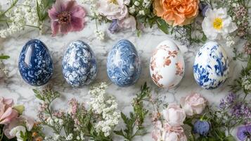 Decorative eggs arranged on a marble surface surrounded by colorful flowers for a festive spring celebration photo
