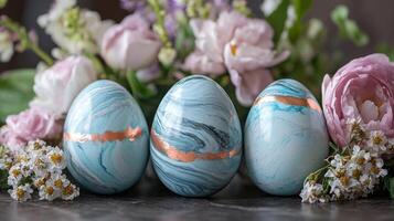 Decorative blue marble eggs arranged with fresh flowers in a serene spring setting photo
