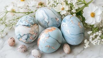 Decorative eggs with marble patterns and floral accents on a marble surface, captured in a soft light setting photo