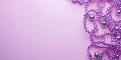 Colorful purple beads with reflective spheres create a vibrant decorative arrangement on a soft pink background photo
