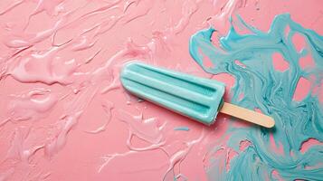 Bright blue popsicle rests on pink and blue swirled background in a fun summer setting photo