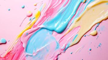 Colorful abstract paint swirls create a vibrant and playful background on a pink surface with a blend of pastels photo