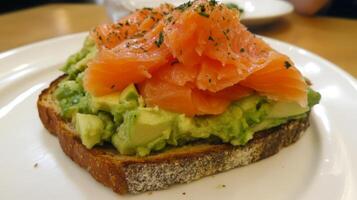 Avocado toast topped with smoked salmon served on whole grain bread at a cozy cafe photo