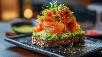 Delicious avocado toast topped with smoked salmon and microgreens served on a dark plate in a modern restaurant setting photo