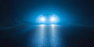 Bright lights illuminate a dark road on a misty night, creating an atmosphere of mystery and intrigue photo