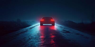 Car illuminated by red lights driving on a wet road at night with fog and dark surroundings photo