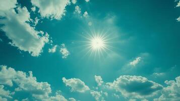 Bright sun shines in a clear blue sky with wispy clouds during a warm afternoon in a serene outdoor setting photo