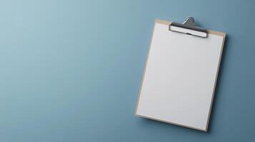 Blank clipboard ready for notes in a modern workspace setting on a calm blue backdrop photo