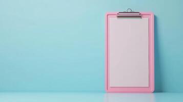 Clipboard with blank sheet against a light blue wall ready for notes or sketches photo