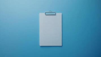 Blank clipboard with lined paper on a blue background for notes and organization tasks photo