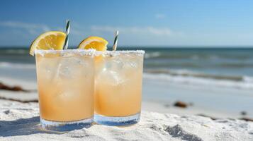 Refreshing cocktails on the beach with lemon slices and salt rim overlooking the ocean on a sunny day photo
