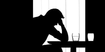 Emotional reflection at a table with glasses of water in a dimly lit room photo