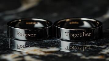 Elegant wedding rings inscribed with Forever and Together resting on a marble surface photo