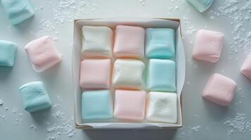 Colorful marshmallows arranged in a box on a light surface with sugar powder photo