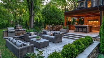 Outdoor lounge area with modern seating and kitchen under evening sky in a landscaped backyard photo