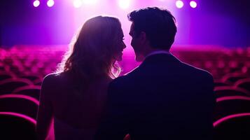Couple sharing a romantic moment in a theater with soft purple lighting during a special event or performance photo